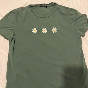 Small t-shirt with three flowers on front. Green/blue color.